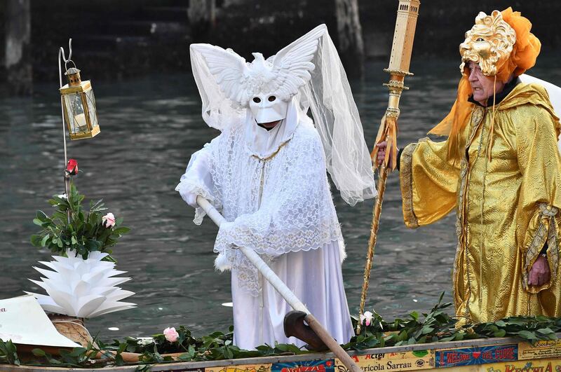 Masked revellers wearing traditional carnival costumes sail on the Venice Grand Canal on a self made gondola In Venice on February 16, 2019.  / AFP / Vincenzo PINTO
