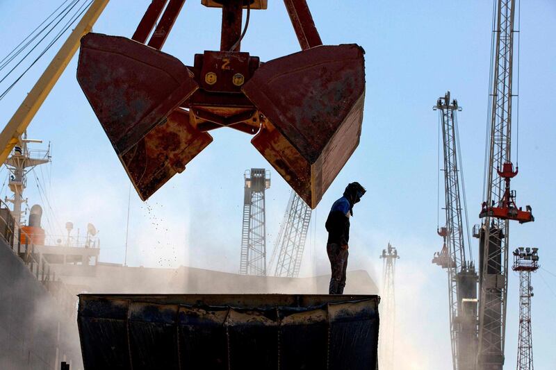A dockyard grab overshadows a worker as a shipment of corn arrives at Umm Qasr near Basra. AFP