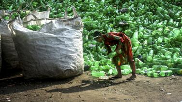 A girl collects plastic bottles at a waste collection park in Bangladesh. Getty Images