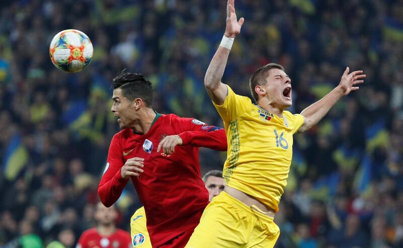 Soccer Football - Euro 2020 Qualifier - Group B - Ukraine v Portugal - NSC Olympiyskiy, Kiev, Ukraine - October 14, 2019 Ukraine's Vitaliy Mykolenko in action with Portugal's Cristiano Ronaldo REUTERS/Valentyn Ogirenko