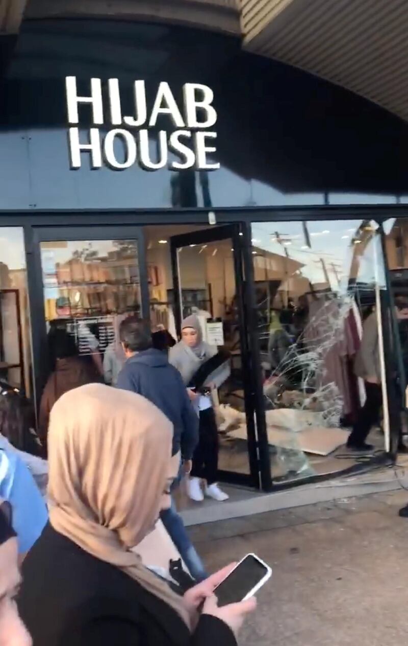 People walk past the shattered storefront window of the Hijab House window after a car crashed into the shop in the Greenacre suburb of Sydney, Australia on May 21, 2020. Reuters