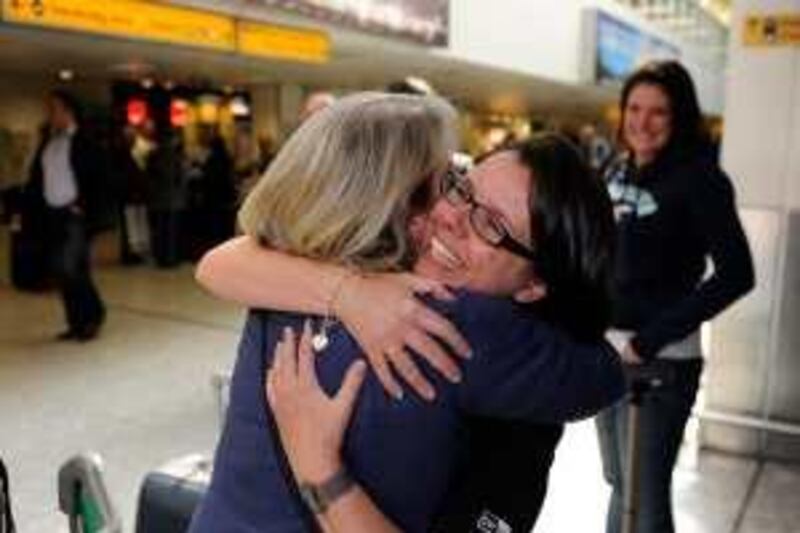 Work colleagues Jaqueline Wood (L) and Tara Roe Gammon, embrace  after returning from Costa Rica via Madrid, at Heathrow Airport in west London April 21, 2010. Europe's skies were opened for business on Wednesday, but with so many planes having been grounded by the pall of volcanic ash spreading from Iceland it could take days, or weeks, to clear the backlog.    REUTERS/Paul Hackett   (BRITAIN - Tags: TRANSPORT ENVIRONMENT TRAVEL) *** Local Caption ***  PMH12_EUROPE-AIR-_0421_11.JPG