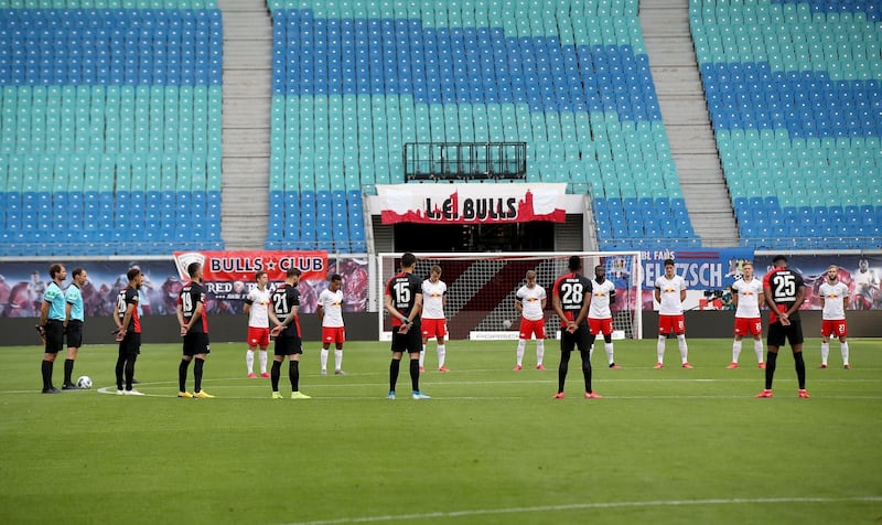 Players observe a minute's silence for the victims of the coronavirus prior to the match. AFP