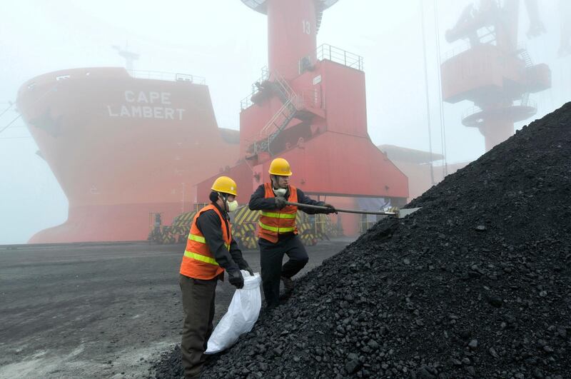In this Feb. 24, 2010, photo, inspection and quarantine workers take samples of imported coal at a port in Rizhao in eastern China's Shandong province. Australia's Trade Minister Simon Birmingham said Friday, Feb. 22, 2019, that while there might be some delays in the processing of coal shipments at Chinese ports, he has no reason to believe China is banning Australian coal. (Chinatopix via AP)