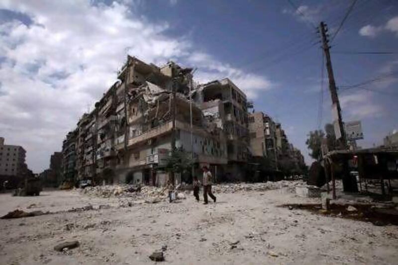 Syrians walk by a building damaged in a government airstrike in Aleppo.