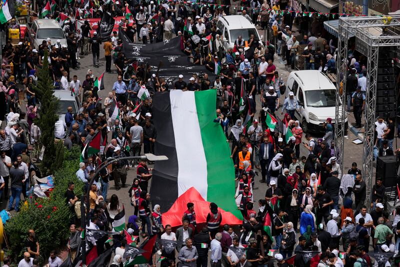Palestinians carry a large national flag during a Nakba Day rally to mark the displacement of thousands of Palestinians after the founding of the Israeli state in the aftermath of the Second World War. AP