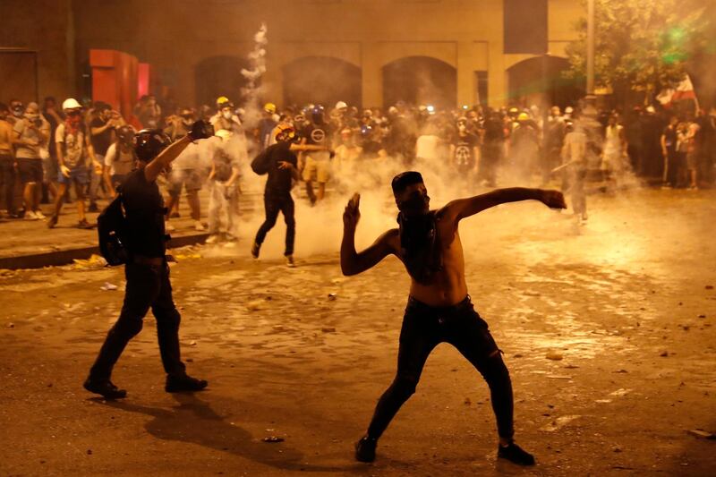 A protester throws stones against the Lebanese riot police. AP
