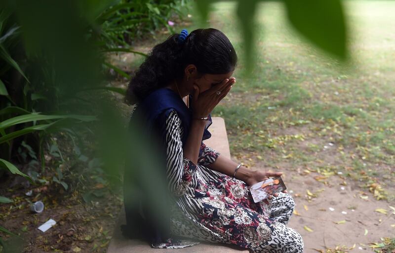 To go with "INDIA-MARRIAGE-CHILDREN-CRIME" by Annie BANERJI
In this photograph taken on August 24, 2015, 20 year old Indian student Santa Devi Meghwal, a victim of child marriage holds a photograph of the ceremony, in Jodhpur. Meghwal was only 11 months-old when her elders married her to a nine-year-old boy from a neighbouring village in the desert state of Rajasthan, where rates of child marriages have long been high.  AFP PHOTO / MONEY SHARMA (Photo by MONEY SHARMA / AFP)