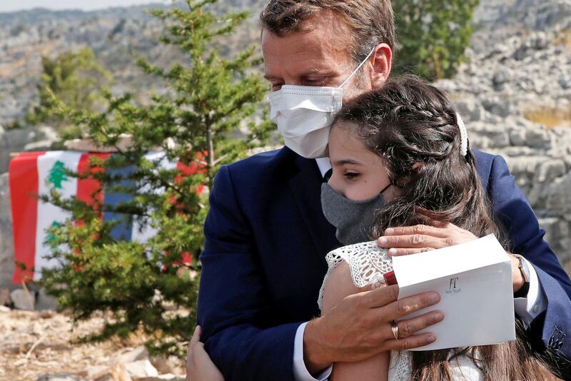 French President Emmanuel Macron hugs a blast victim while attending a ceremony to mark Lebanon's centenary in Jaj Cedars Reserve Forest on September 1, 2020. AFP