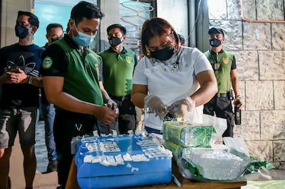 Agents place tags on the bags of seized drugs. AP