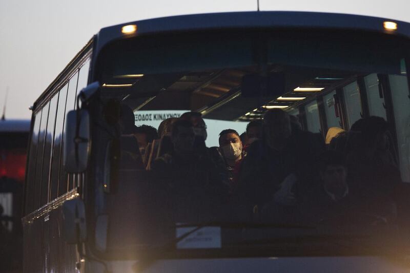 Migrants arrive on a bus at the port of Mytilini on the Greek island of Lesbos on Monday during the first day of the implementation of the deal between EU and Turkey. Petros Giannakouris / AP