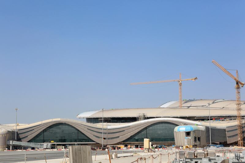 A passenger boarding bridge, left, sits beside an aircraft parking area under development Abu Dhabi airport's MidField terminal during construction in Abu Dhabi, United Arab Emirates, on Monday, Nov. 6, 2017. The project will cost 19.1 billion dirhams, will have a capacity to handle 84 million passengers, or 11,000 passengers per hour and have 65 gates. Photographer: Natalie Naccache/Bloomberg