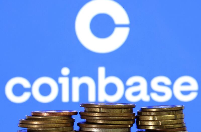 A representation of cryptocurrency in front of the Coinbase logo. AFP