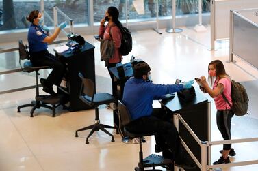 TSA agents help travelers as they clear security for flights out of Love Field in Dallas, on June 24, 2020. AP.