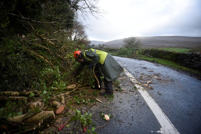 A worker clears fallen trees off a road during Storm Ophelia in the County Clare area of the Burren, Ireland. Clodagh Kilcoyne / Reuters