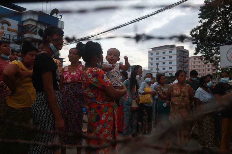 People wait with their children in hopes of being reunited with family members. AP