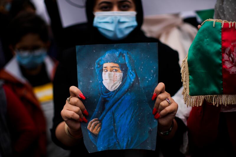 A woman holds a photograph during a protest to raise awareness of the situation in Afghanistan, outside EU headquarters in Brussels. AP Photo
