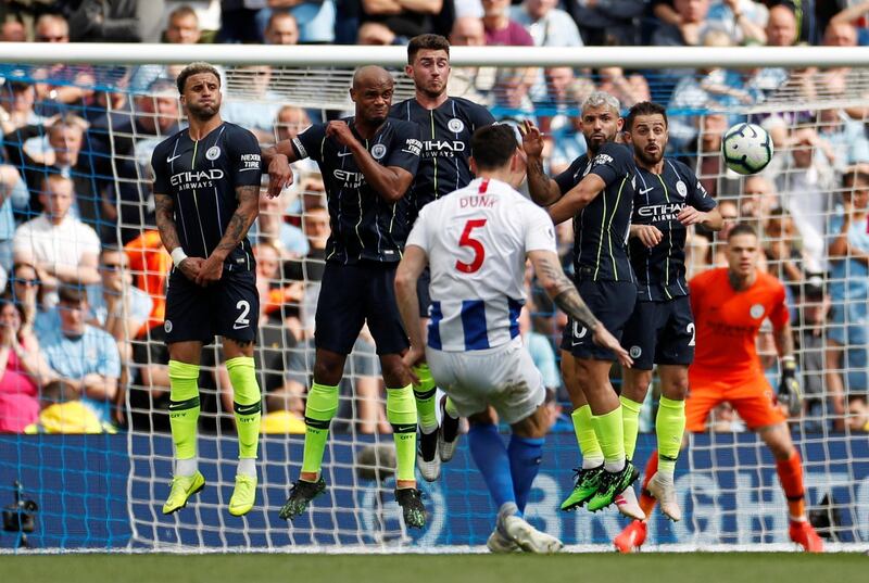 Manchester City's Kyle Walker, Vincent Kompany, Aymeric Laporte, Sergio Aguero and Bernardo Silva form a wall to defend a free kick taken by Brighton's Lewis Dunk. Reuters