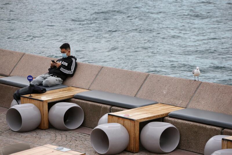 A person sits alone in the Opera House cafe area at Circular Quay in Sydney, Australia. Getty Images