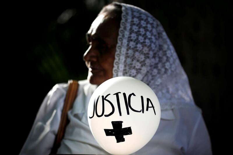 A woman holds a balloon that reads "Justice" during a protest against an amnesty bill to avoid prosecuting crimes committed during the civil war in San Salvador, El Salvador. Reuters