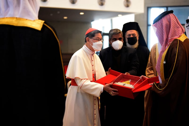 Cardinal Luis Antonio Tagle, centre, presents a replica of Our Lady of Arabia Cathedral to Sheikh Abdullah. Mazen Mahdi / AFP