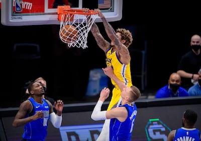 Feb 4, 2021; Dallas, Texas, USA; Golden State Warriors guard Kelly Oubre Jr. (12) dunks the ball over Dallas Mavericks forward Dorian Finney-Smith (10) and forward Kristaps Porzingis (6) during the second quarter at the American Airlines Center. Mandatory Credit: Jerome Miron-USA TODAY Sports