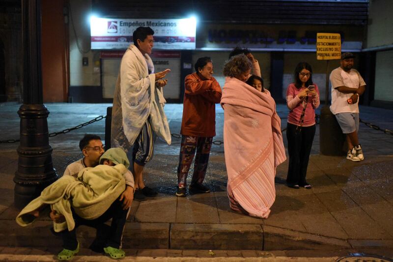 Residents stand outside their homes in Mexico City after a 6.8-magnitude earthquake rocked the country. AFP