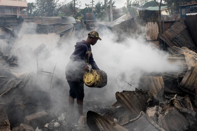 A man pours water on burning ruins of Kikuyu homes and shops which were destroyed in the Kawangware slum in Nairobi, Kenya. Andrew Renneisen / Getty Images