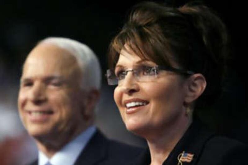 Senator John McCain looks on as his vice-presidential running mate, the Governor of Alaska Sarah Palin, speaks at a campaign event in Dayton, Ohio on Aug 29.