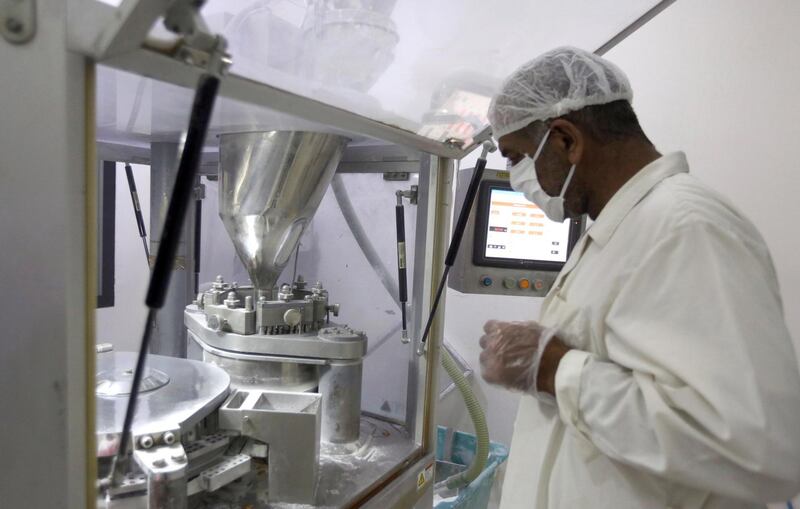 A laboratory technician stands next to drug-making machine at the Syrian Tamico Pharmaceutical Factory in Damascus. The factory is producing Azithromycin tablets, which are used with hydroxychloroquine as one of the treatments for patients with Covid-19, however a recent study revealed this combination may be associated with increased mortality. Youssef Badawi / EPA