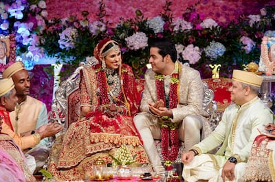 In this Saturday, March 9, 2019 photo, Akash Ambani, second right, son of Reliance Industries Chairman Mukesh Ambani and his wife Shloka Mehta smile as they perform a ritual at their wedding ceremony in Mumbai, India. (Reliance Industries Limited Photo via AP)