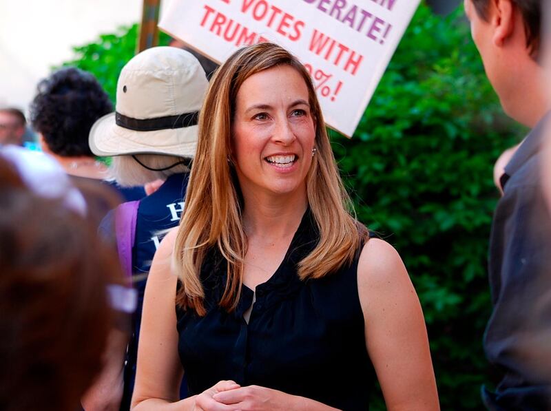 FILE- In this May 19, 2017, file photo, Mikie Sherrill joins protesters with NJ 11th for Change outside of U.S. Rep. Rodney Frelinghuysen's Morristown office. Sherrill, a former Navy helicopter pilot and federal prosecutor, is looking to capture a GOP congressional seat in New Jersey. Sherrill is one of some 200 women who have won their primaries for U.S. House, with 94 of these candidates surviving crowded fields with three or more candidates, according to an analysis of election results. (Justin Zaremba/NJ Advance Media via AP, File)