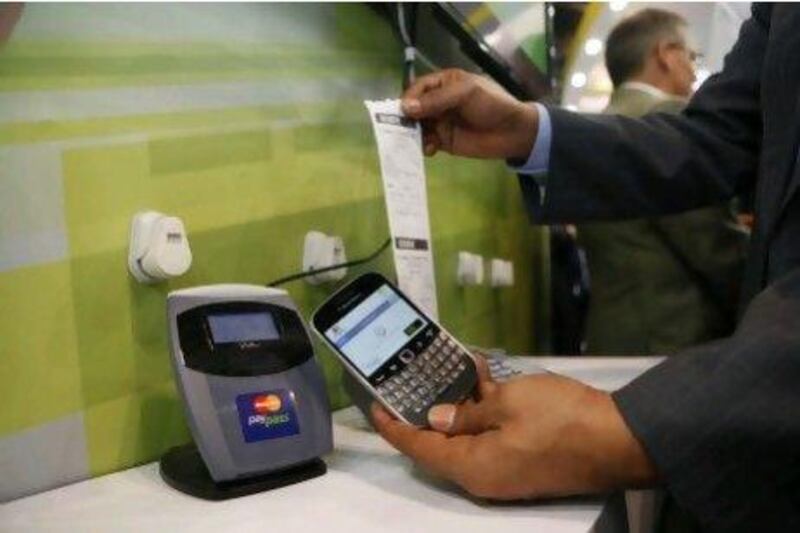 An Etisalat employee demonstrates the new payment system. Antonie Robertson / The National