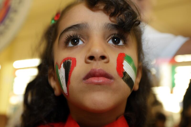 UAE - Ajman- Dec 02 - 2011: A girl with her face painted with the colors of the UAE flag at city centre mall during the celebration of the 40 year anniversary of the National day. ( Jaime Puebla - The National Newspaper )