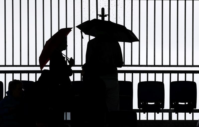 Spectators use umbrellas during rain at Melbourne Park, Melbourne, Australia. Reuters