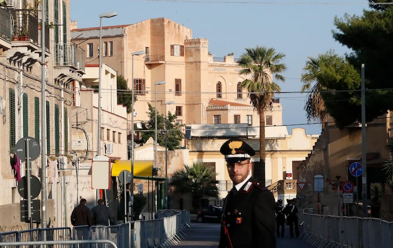 A Carabinieri (Italian paramilitary) officer patrols the area next to Villa Igiea, the site of an international conference on Libya, in Palermo, Italy, Monday, Nov. 12, 2018. A gathering of leaders of Libya's quarrelling factions and of countries keen on stabilizing the North African nation is taking place Sicily. It aims to find a political settlement that would bolster the fight against Islamic militants and stop illegal migrants crossing the Mediterranean to Europe's southern shores. (AP Photo/Antonio Calanni)