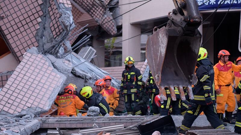 Firefighters in the wreckage of a collapsed building. AP