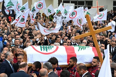Mourners carry the coffin of Pascal Sleiman at his funeral in Byblos. Several Lebanese Forces flags can be seen in the background. EPA