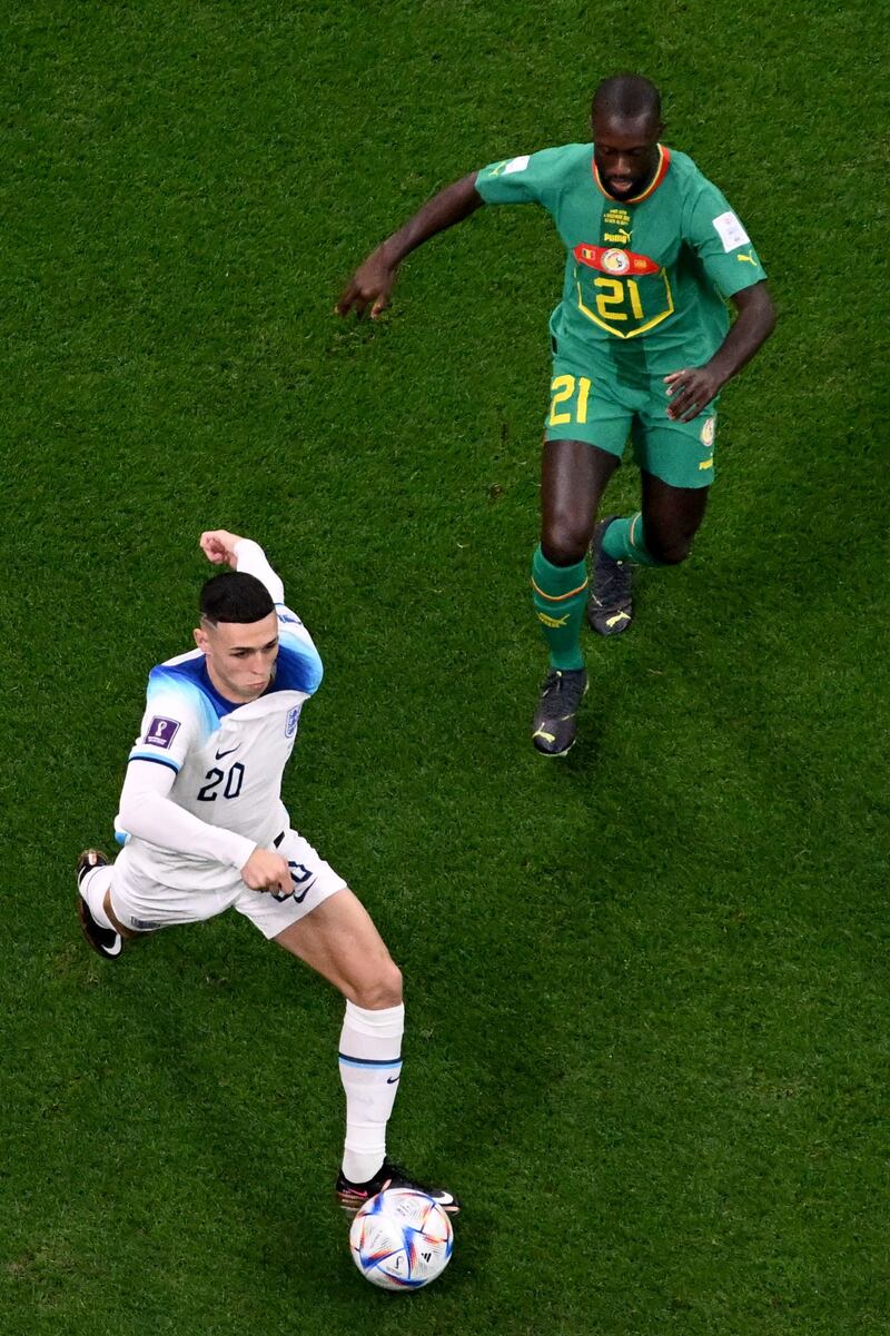 England's Phil Foden breaks with Senegal's Youssouf Sabaly in pursuit. AFP