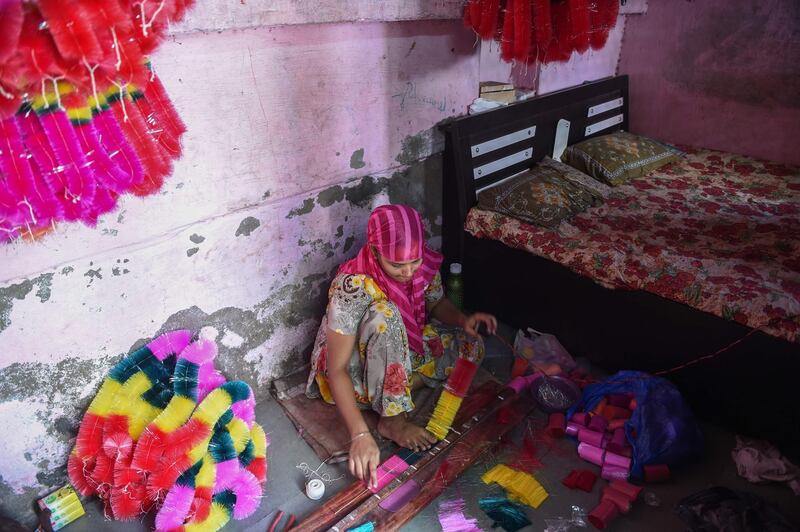 A worker makes garlands from coloured polyster/silk yarn ahead of the Hindu festival of Diwali in Ahmedabad on October 17, 2019. Colourful garlands are in demand during the Hindu festival of Diwali, or Festival of Lights, which falls on October 27 this year. AFP