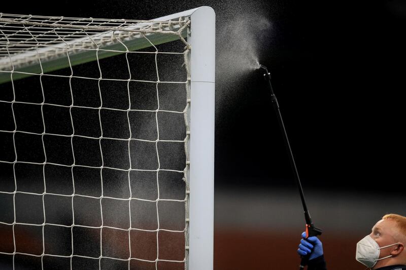 A worker disinfects the goal post before the Premier League match between Tottenham Hotspur and Everton at the Tottenham Hotspur Stadium in London. AP Photo