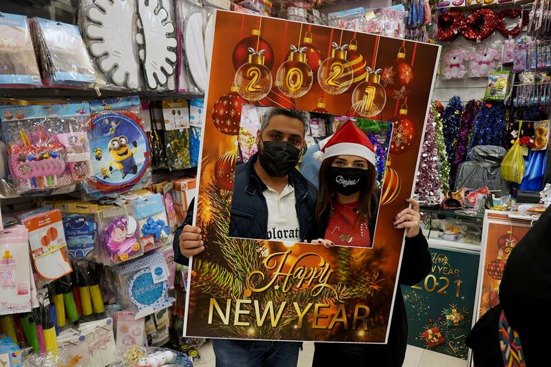 Ziad, a Muslim man, and his wife Lamees Homidan, a Lebanese Christian, pose through a print at a shop selling various items for Christmas celebrations, after the government eased restrictions on the sale of Christmas ornaments and decorations, in Riyadh, Saudi Arabia.  Reuters