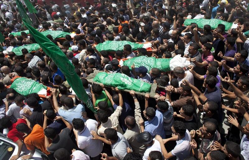 Six children from the Al Hajj family, along with their parents, were killed when the three Israeli strikes smashed into the house, according to residents. Shown here, Palestinians carry the bodies of the eight members of the Al Hajj family . Heidi Levine for The National