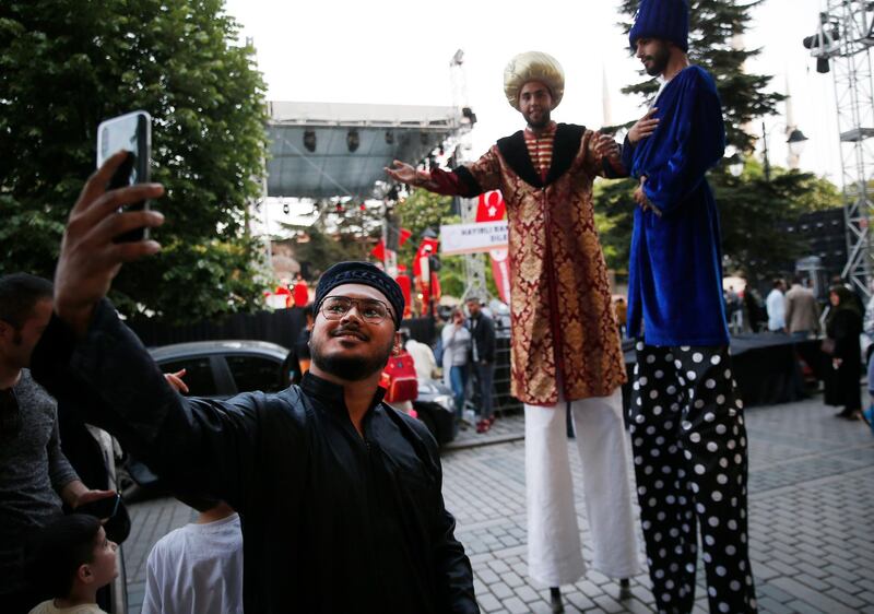 A tourist poses for photos with men in Ottoman attire in the historic Sultanahmet district of Istanbul.  AP Photo