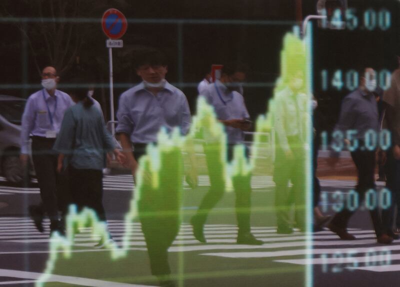 Pedestrians are reflected on a board displaying a graph of the Japanese yen exchange rate against the US dollar. The greenback is expected to continue rising against currencies such as the yen, euro and British pound. Reuters