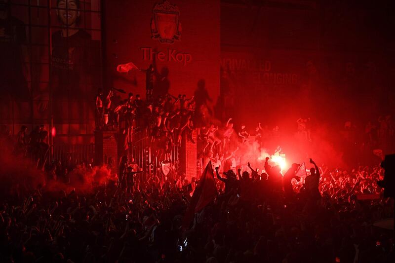 Fans celebrate Liverpool winning the Premier League title outside Anfield stadium. AFP