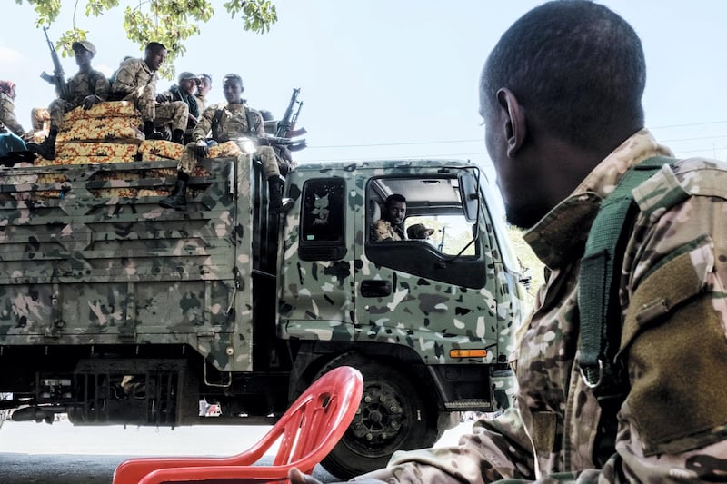 Members of the Amhara Special Forces seat on the top of a truck while another member looks on in the city of Alamata, Ethiopia, on December 11, 2020. (Photo by EDUARDO SOTERAS / AFP)