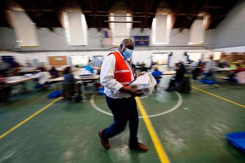 James Lyles, a Chester County election worker, carries mail-in and absentee ballots for the 2020 general election in the United States to be processed at West Chester University, in West Chester, Pa. AP Photo