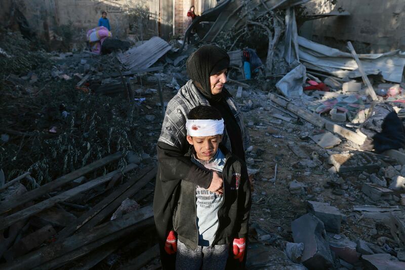 A Palestinian woman with an injured boy in the rubble of a building after an Israeli bombardment in Rafah, in the southern Gaza Strip. AFP