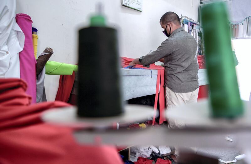 Abu Dhabi, United Arab Emirates, April 18, 2020.  The Carpet Souk at the Zayed Port area.  An   upholsterer cuts fabric for a Ramadan sofa.
Victor Besa / The National
Section:  NA
For:  Standalone/Stock Images